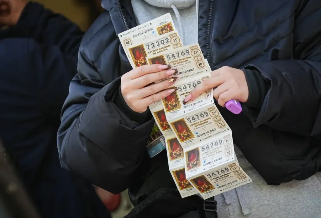 Persona muestra los décimos de la lotería de navidad que juega este 2025 / Europa Press