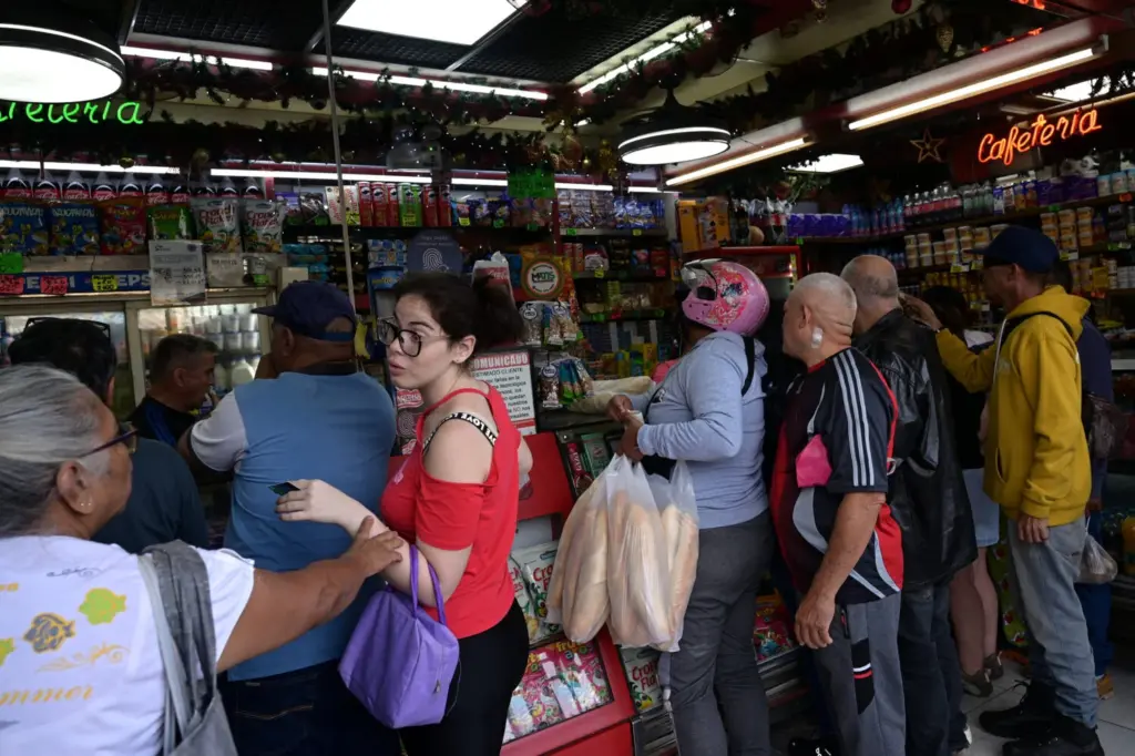 La gente compra comida en una tienda, después de que el presidente de Estados Unidos, Donald Trump, dijera que Estados Unidos atacó a Venezuela y capturó a su presidente, Nicolás Maduro, en Caracas, Venezuela, el 3 de enero de 2026. REUTERS/Gaby Oraa