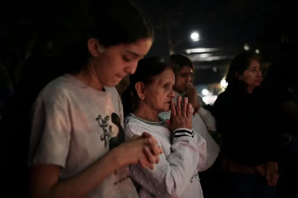 Familiares rezan mientras se reúnen afuera de la cárcel de El Rodeo luego de que el presidente de la Asamblea Nacional de Venezuela, Jorge Rodríguez, anunciara que un número significativo de presos extranjeros y venezolanos serán liberados, en El Rodeo, estado Miranda, Venezuela, el 9 de enero de 2026. REUTERS/Gaby Oraa