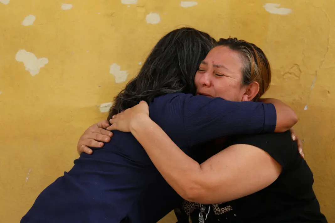 Evelis Cano, madre de Jack Tantak Cano, de 31 años, quien fue arrestado en noviembre de 2025, abraza a una persona mientras familiares de los detenidos esperan afuera del Centro de Detención de la Zona 7 de la Policía Nacional mientras el gobierno de Venezuela comienza a liberar a algunos detenidos