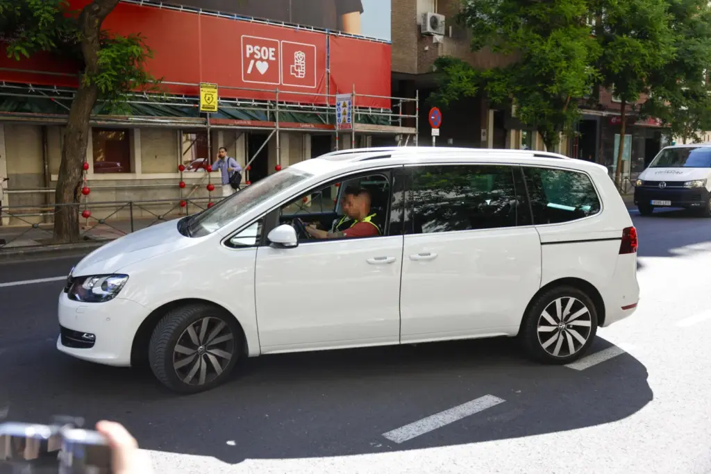 Un coche de la policía nacional circula ante la sede del PSOE, en Madrid (al fondo). EFE/ Rodrigo Jimenez