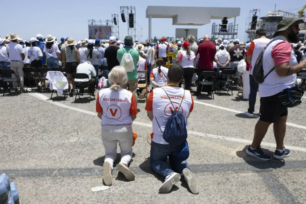 Miles de personas asistieron este viernes a la misa que ofició el papa León XIV en el puerto de Santa Cruz de Tenerifeen su último día de viaje a España. En la imagen, dos voluntarios durante la misa. EFE/Miguel Barreto
