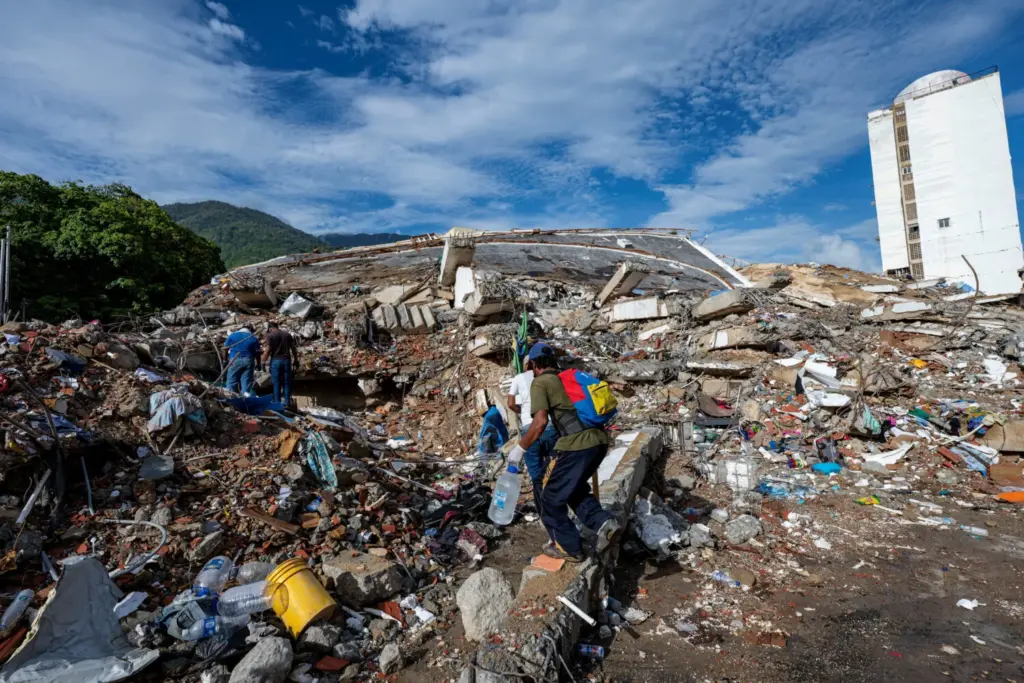 Voluntarios caminan entre los escombros de un edificio derrumbado tras los dos terremotos del 24 de junio en Caraballeda, Venezuela, el 30 de junio de 2026. MIGUEL MEDINA/Pool vía REUTERS