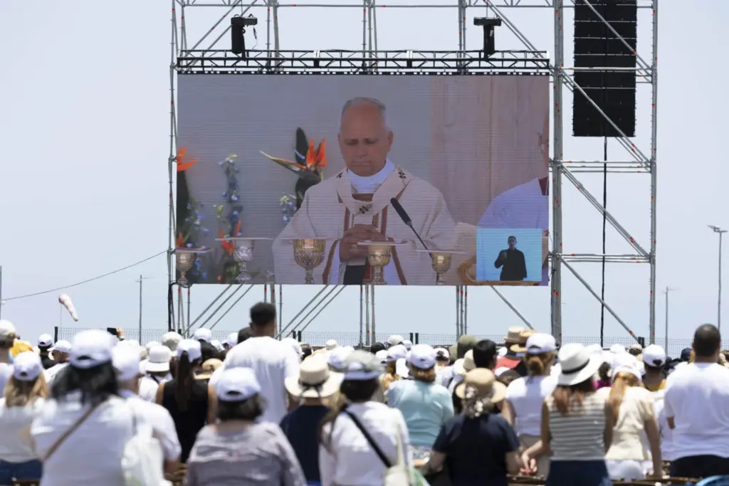 Miles de personas asistieron este viernes a la misa que ofició el papa León XIV en el puerto de Santa Cruz de Tenerifeen su último día de viaje a España. En la imagen, fieles siguen la misa en una pantalla gigante. EFE/Miguel Barreto