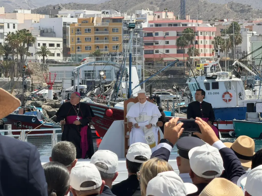 El Papa junto al obispo Mazuelos escuchan los testimonios de quienes arienden a las personas que llegan al muelle de Arguineguín