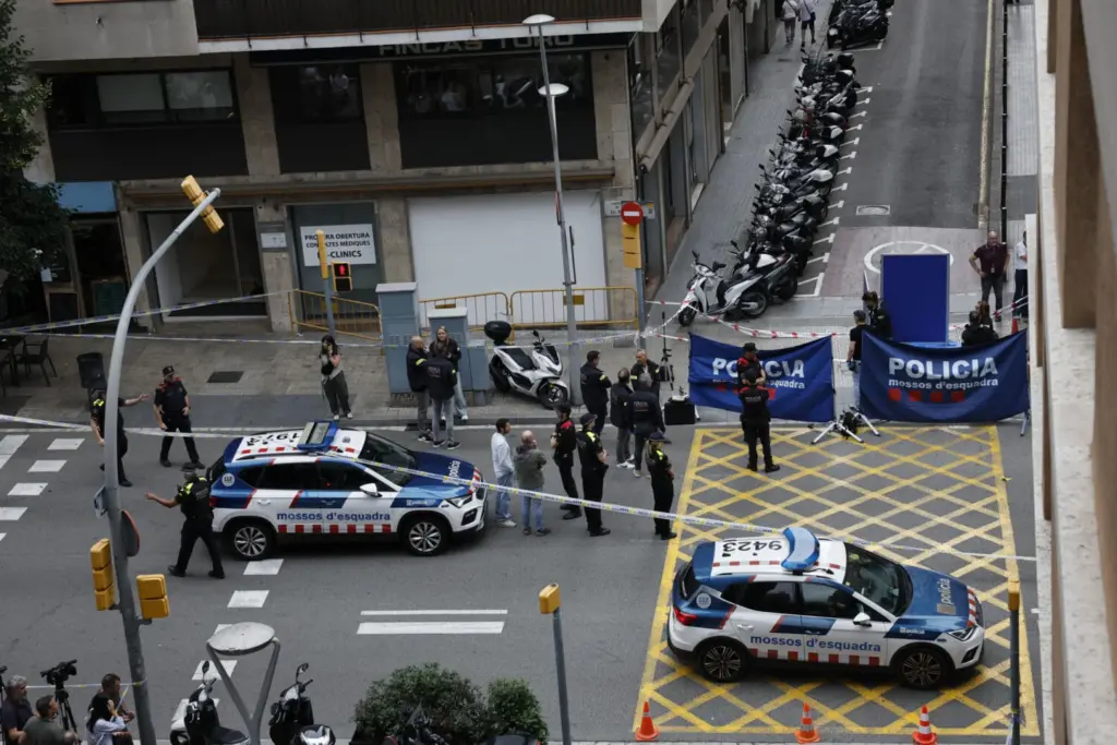 Agentes de los Mossos d'Esquadra junto en la calle Balmes, en el distrito de Sarrià-Sant Gervasi de Barcelona, donde este miércoles un hombre ha sido asesinado a tiros. El crimen, que investigan los Mossos d'Esquadra, ha ocurrido a las 9:50 horas muy cerca de una comisaría de la Policía Nacional. EFE/ Alberto Estévez