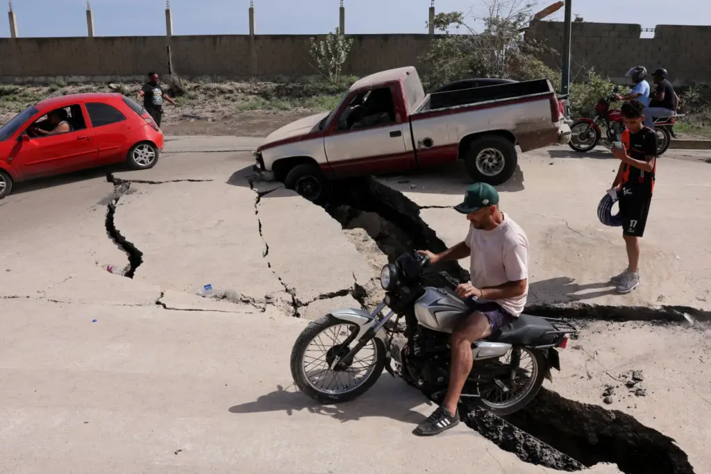 Un hombre está sentado en una bicicleta en una carretera dañada tras los terremotos que afectaron al país, en La Guaira, Venezuela, el 25 de junio de 2026. REUTERS/Gaby Oraa