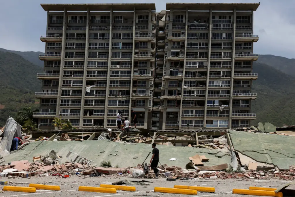 Personas inspeccionan los escombros de un edificio colapsado tras los terremotos que afectaron al país, en La Guaira, Venezuela, el 25 de junio de 2026. REUTERS/Gaby Oraa