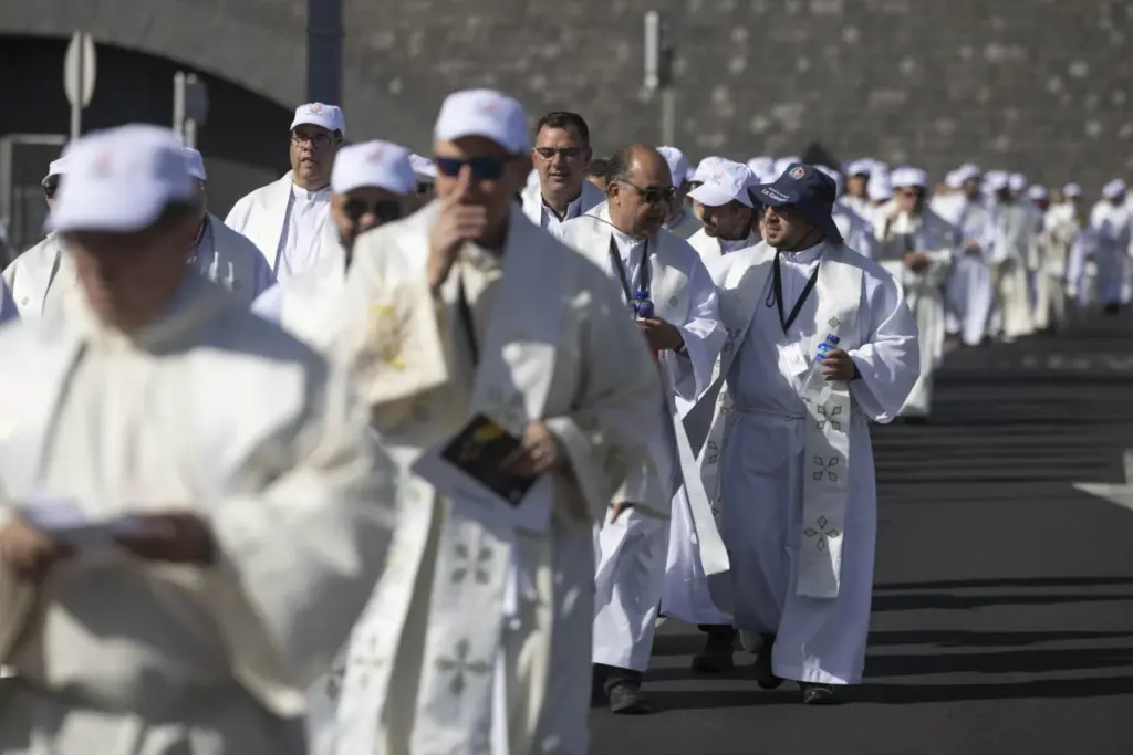 Numerosos sacerdotes salen de la sacristía instalada en el Auditorio Adán Martín de Santa Cruz de Tenerife para la misa del papa León XIV en el puerto de la ciudad ante miles de personas. EFE/Miguel Barreto
