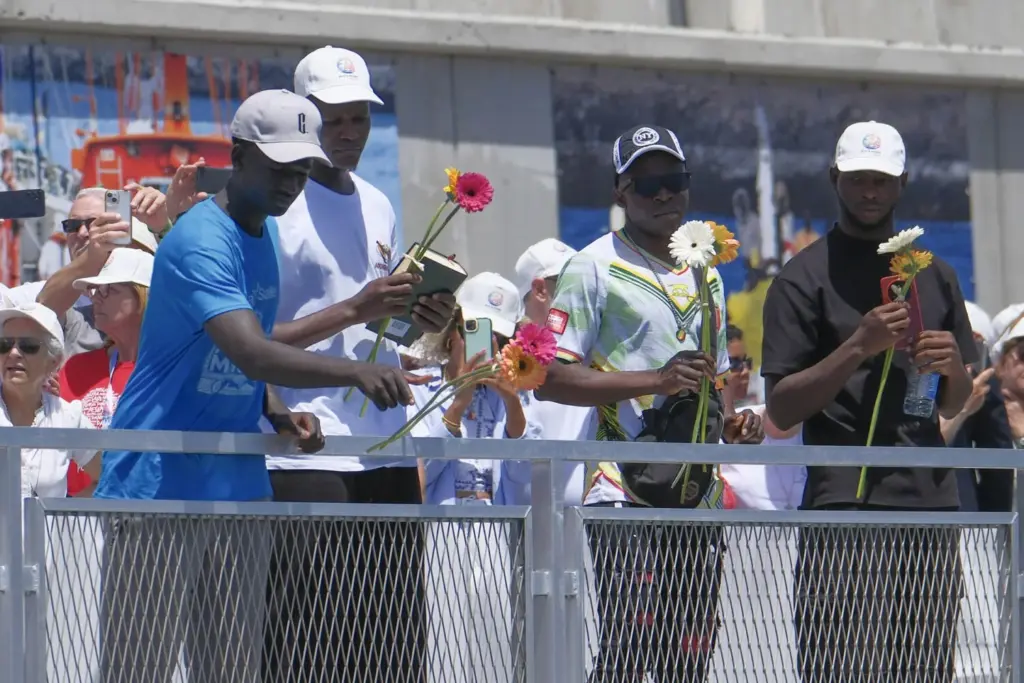 Asistentes lanzan flores al mar en recuerdo de los migrantes muertos en la travesía durante el encuentro que el papa León XIV ha mantenido con más de un millar de inmigrantes de África, América Latina y con representantes de las principales instituciones y organizaciones sociales que trabajan en los servicios de rescate, acogida e integración en el muelle de Arguineguín, en la isla de Gran Canaria, este jueves, en el sexto día de su viaje a España. EFE/ Angel Medina G. POOL
