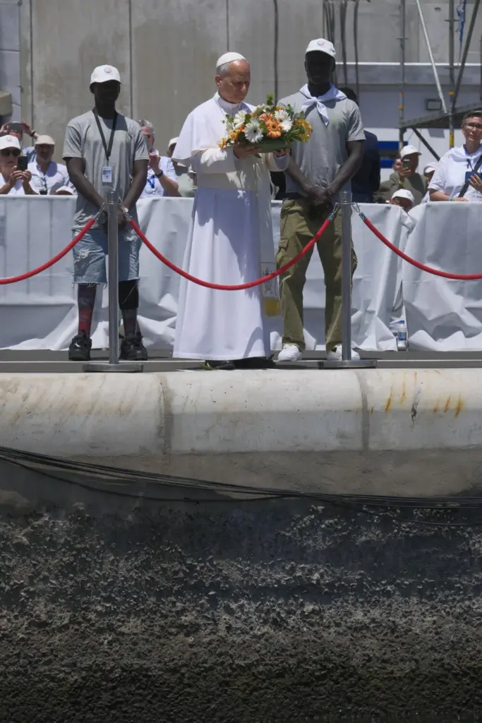 El papa León XIV se dispone a lanza una corona de flores al mar en recuerdo de los migrantes muertos en la travesía durante el encuentro con más de un millar de inmigrantes de África, América Latina y con representantes de las principales instituciones y organizaciones sociales que trabajan en los servicios de rescate, acogida e integración en el muelle de Arguineguín, en la isla de Gran Canaria, este jueves, en el sexto día de su viaje a España. EFE/ Angel Medina G. POOL