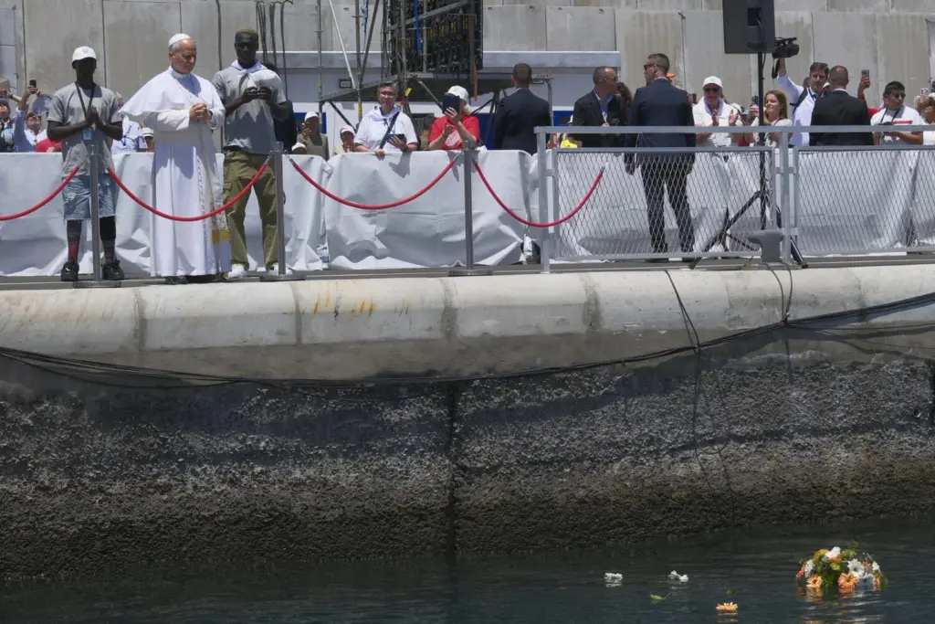 El papa León XIV lanza una corona de flores al mar en recuerdo de los migrantes muertos en la travesía durante el encuentro con más de un millar de inmigrantes de África, América Latina y con representantes de las principales instituciones y organizaciones sociales que trabajan en los servicios de rescate, acogida e integración en el muelle de Arguineguín, en la isla de Gran Canaria, este jueves, en el sexto día de su viaje a España. EFE/ Angel Medina G. POOL