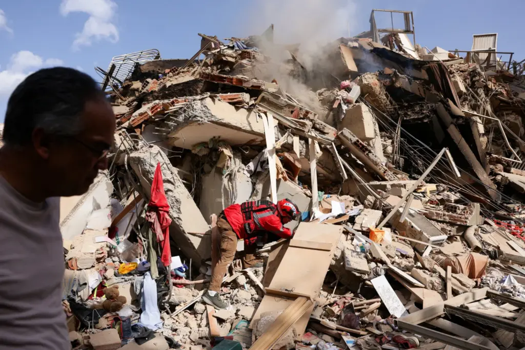 Juan Carlos Gómez, bombero de Caracas, busca a su hermana, Katiuska Hernández, y a su sobrino Brett Roude entre los escombros de un edificio tras los terremotos que azotaron el país, en La Guaira, Venezuela, el 25 de junio de 2026. REUTERS/Gaby Oraa