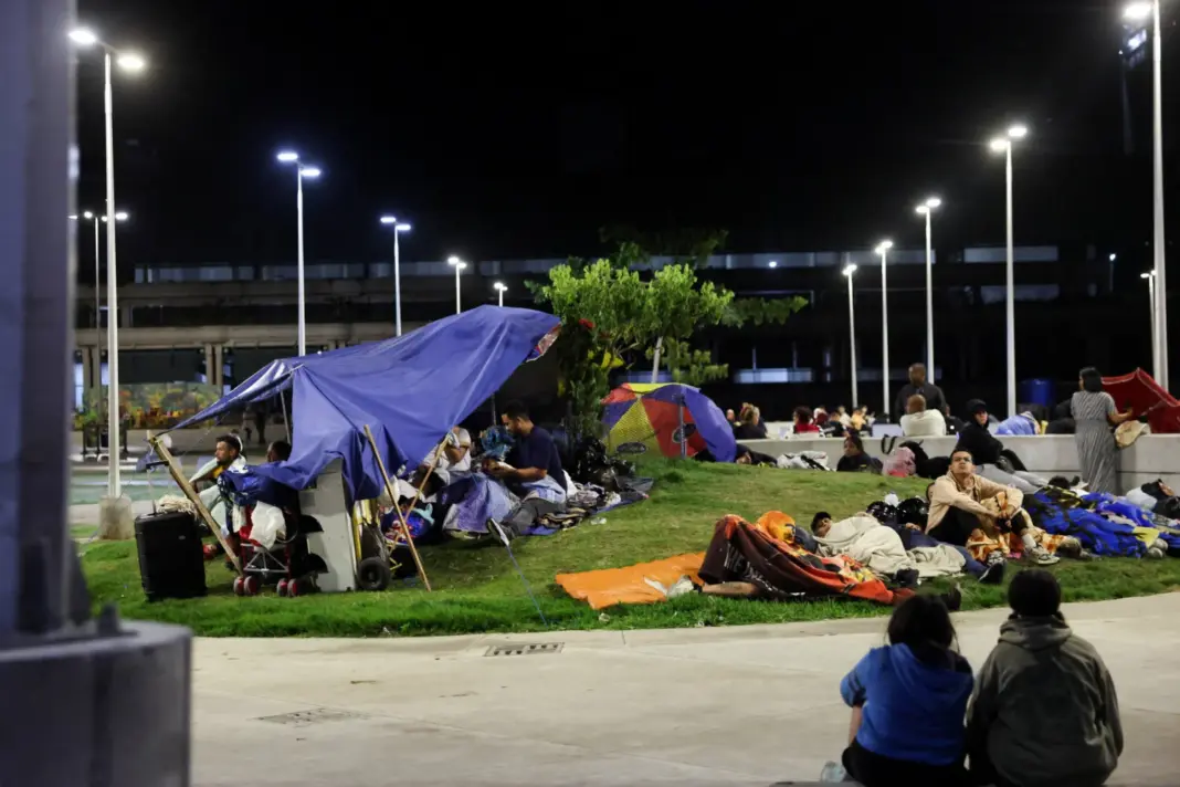 Personas descansan en una plaza por temor a regresar a los edificios, mientras los servicios de emergencia (no aparecen en la imagen) trabajan en el lugar de un edificio colapsado tras los terremotos que afectaron al país, en Caracas, Venezuela, el 25 de junio de 2026. REUTERS/Leonardo Fernandez Viloria