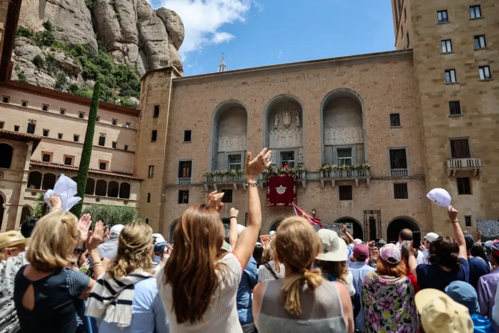 Varias personas se congregan frente a la Abadía de Nuestra Señora de Montserrat mientras el Papa León XIV aparece en un balcón, durante su viaje apostólico, en Montserrat, cerca de Barcelona, ​​España, el 10 de junio de 2026. REUTERS/Yara Nardi