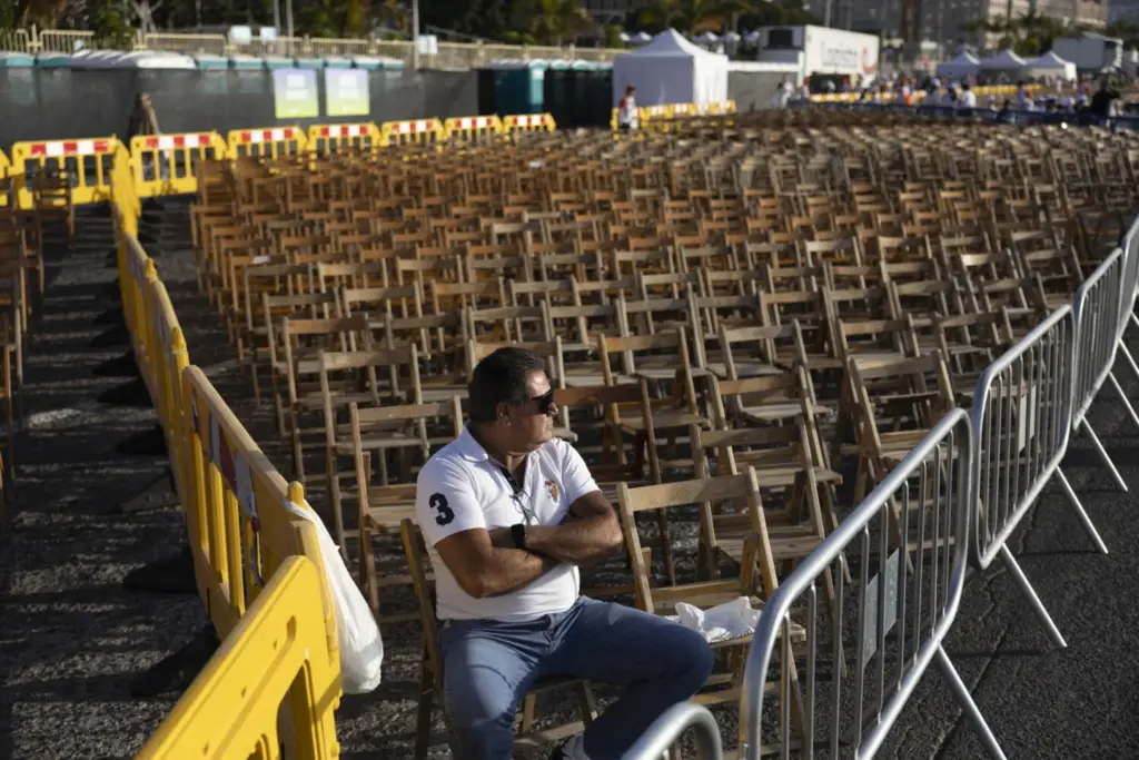 Un hombre espera desde temprano en el puerto de Santa Cruz de Tenerife, donde este viernes el papa León XIV oficia una misa multitudinaria en su último día de viaje. EFE/ Miguel Barreto