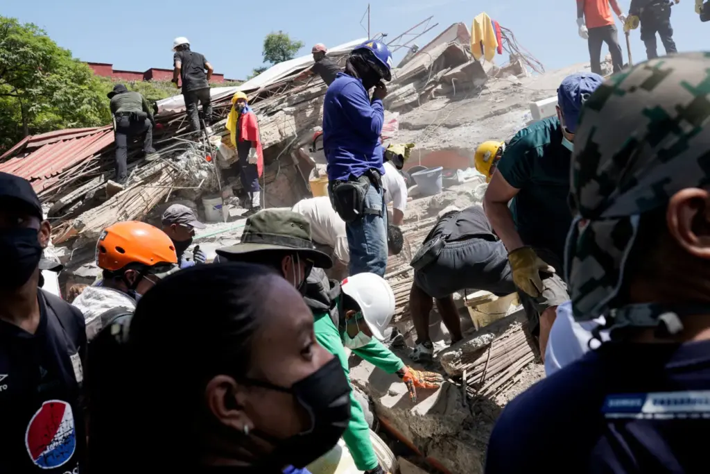 Personas retiran escombros mientras buscan supervivientes en el lugar de un edificio derrumbado, tras el terremoto, en Cali, Colombia, el 11 de agosto de 2026. REUTERS/Sergio Acero