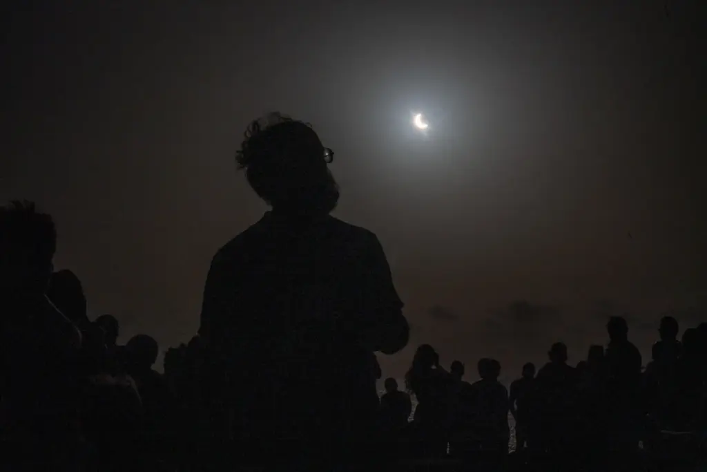 Varias personas contemplan desde El Cotillo, en Fuerteventura, el eclipse solar de este miércoles, que en canarias sólo se pudo ver de forma parcial . EFE/ Carlos De Saá