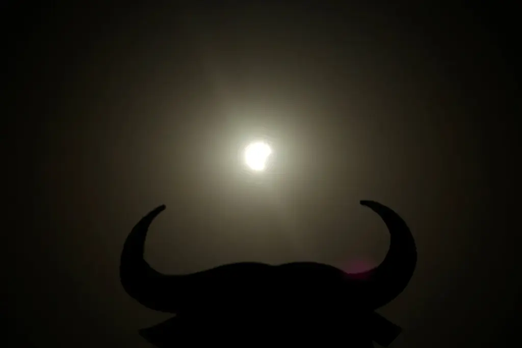 El sol aparece cerca de la silueta de un toro de Osborne antes de la totalidad del eclipse, en Navarrete, norte de España, el 12 de agosto de 2026