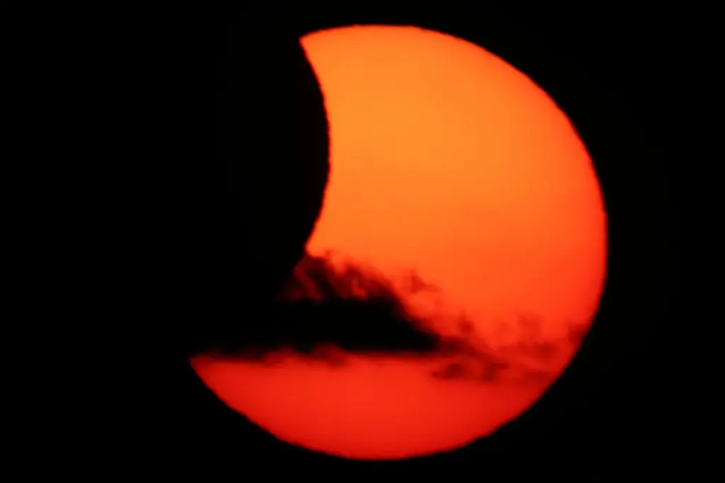 Una nube pasa mientras la luna cubre parcialmente el sol tras un eclipse solar total, visto desde Arija, España, el 12 de agosto de 2026