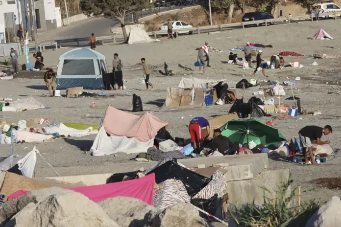 Varios migrantes permanecen este lunes acampados en la playa de El Trampolín de Ceuta.