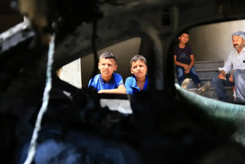 Archivo - Niños palestinos examinan un automóvil calcinado tras un ataque de colonos judíos contra viviendas palestinas- Nasser ishatyeh / Zuma Press / Europa Press