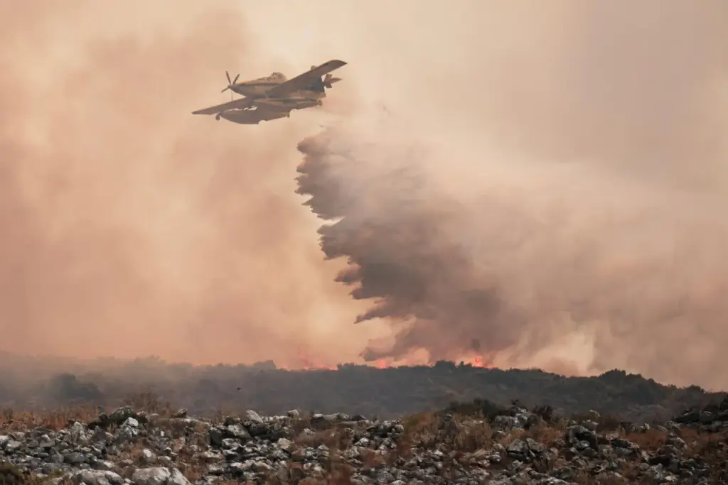 La Junta de Andalucía ha activado esta madrugada la fase de emergencia, en situación operativa 1, ante la evolución del incendio forestal declarado en el término municipal de Igualeja (Málaga), donde se ha decretado el confinamiento de la población y se ha cortado al tráfico la carretera MA-7304. En la imagen, aeronaves del servicio de Bomberos trabajan en la extinción del incendio. EFE/Gregorio Marrero