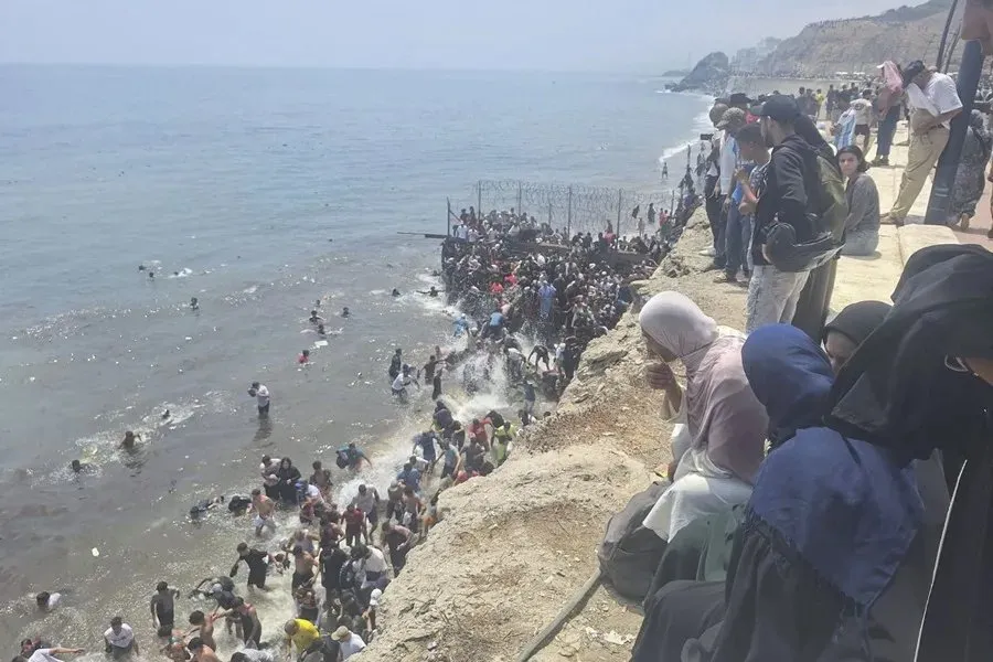 Entrada masiva de personas desde Marruecos a través del espigón de El Tarajal. Imagen EFE