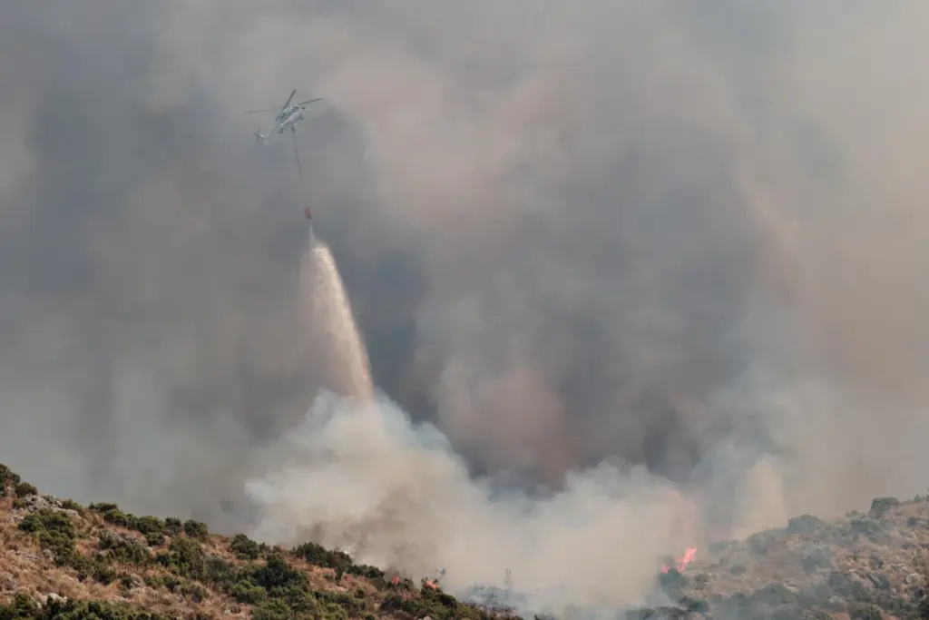 La Junta de Andalucía ha activado esta madrugada la fase de emergencia, en situación operativa 1, ante la evolución del incendio forestal declarado en el término municipal de Igualeja (Málaga), donde se ha decretado el confinamiento de la población y se ha cortado al tráfico la carretera MA-7304. En la imagen, aeronaves del servicio de Bomberos trabajan en la extinción del incendio. EFE/Gregorio Marrero