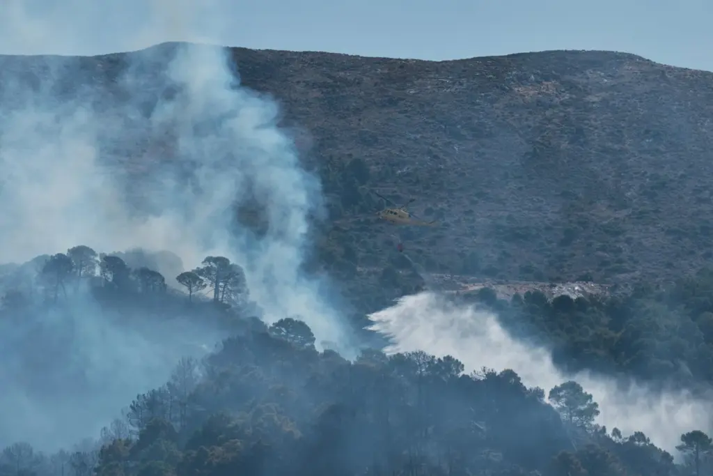 La Junta de Andalucía ha activado esta madrugada la fase de emergencia, en situación operativa 1, ante la evolución del incendio forestal declarado en el término municipal de Igualeja (Málaga), donde se ha decretado el confinamiento de la población y se ha cortado al tráfico la carretera MA-7304. En la imagen, aeronaves del servicio de Bomberos trabajan en la extinción del incendio. EFE/Gregorio Marrero