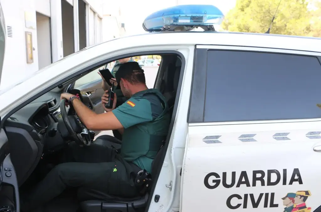 Dos agentes de la Guardia Civil en un coche patrulla