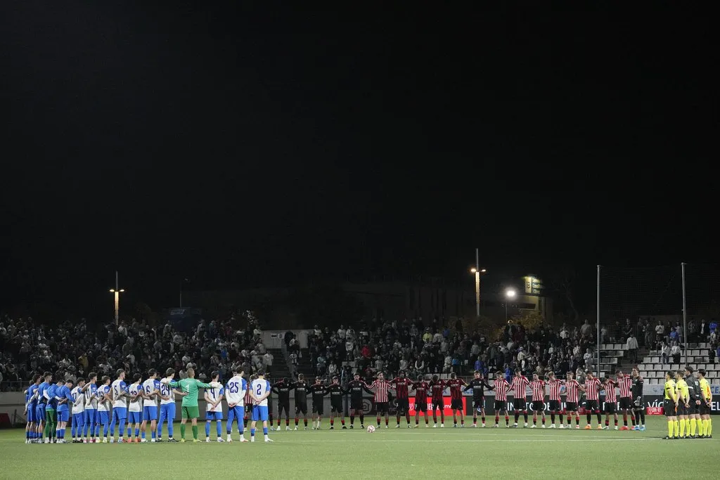 Los jugadores del AE Prat y del Athletic Club de Bilbao guardan un minuto de silencio por las víctimas del accidente