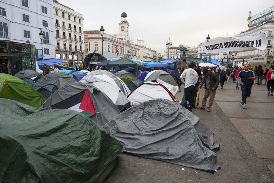 Los manifestantes se levantan este viernes en la acampada de la Puerta del Sol levantada desde hace seis noches en protesta por la situación de la vivienda y que ha amanecido con una tensa calma a la espera de la votación este mediodía de los dos decretos aprobados por el Gobierno y que, salvo sorpresa, no saldrán adelante. EFE/ Kiko Huesca