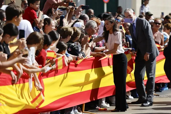 El rey Felipe VI (d) y la reina Letizia (i) saludan a los ciudadanos de Melilla este miércoles a su salida de la Asamblea de la ciudad autónoma. Imagen EFE/Mariscal