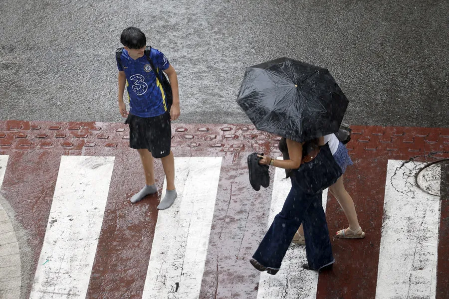 Varias personas en una calle del centro de Barcelona bajo la tormenta. Imagen EFE